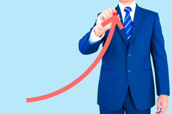 右斜め上にマーカーで矢印を書いている男性