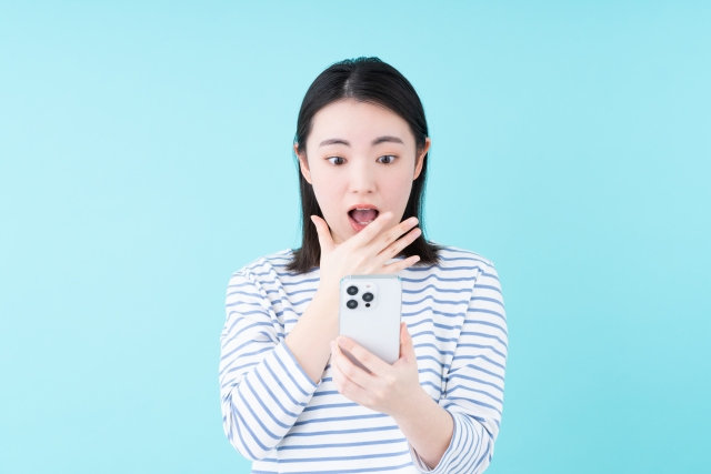 スマホを見て驚く女性