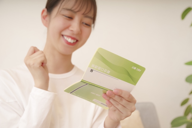 通帳を見て喜ぶ女性